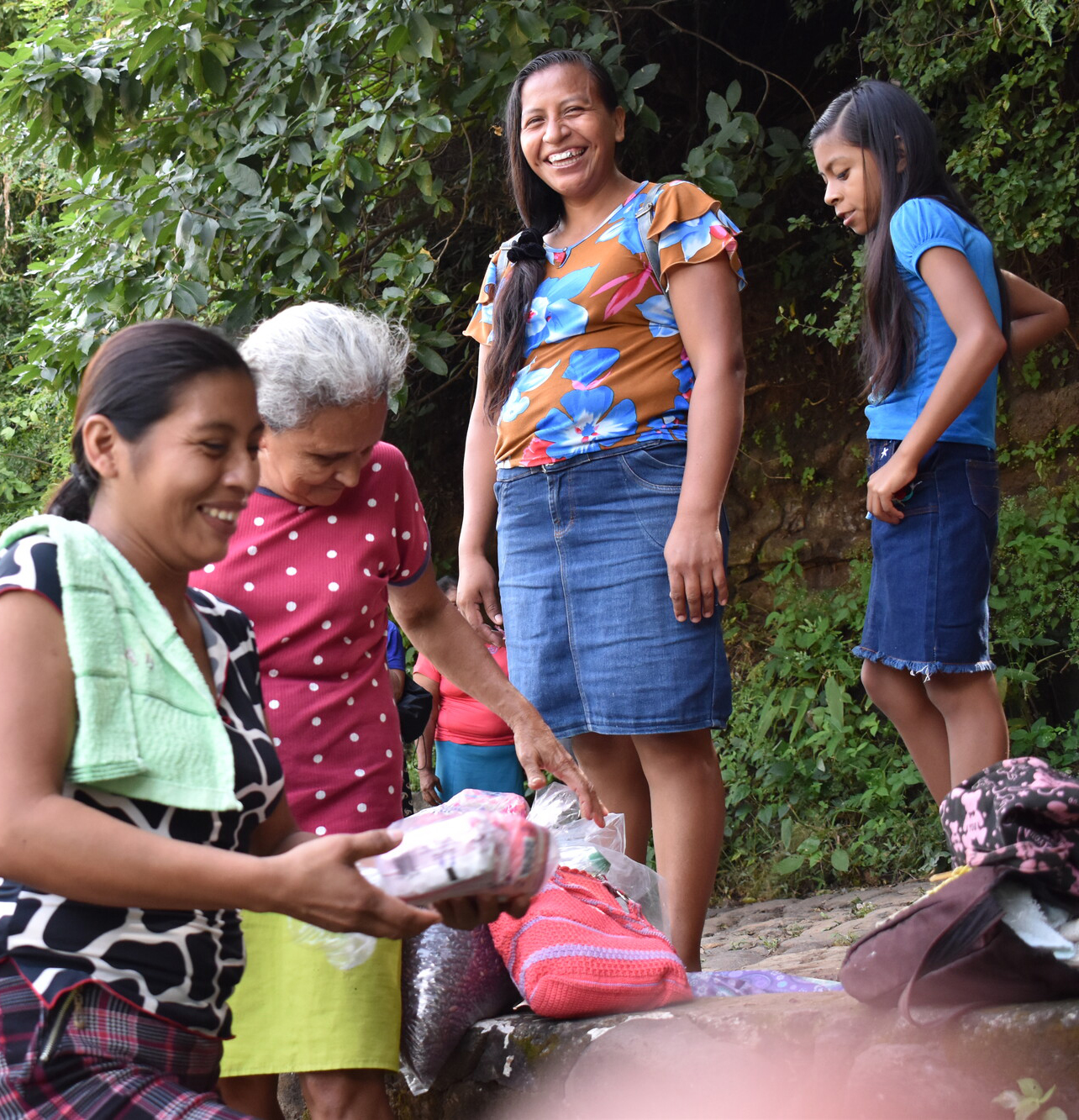 people smiling and sorting food outside