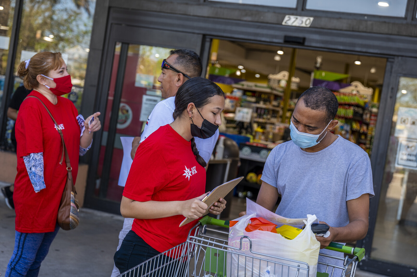 person canvassing with a clipboard outside of a grocery store
